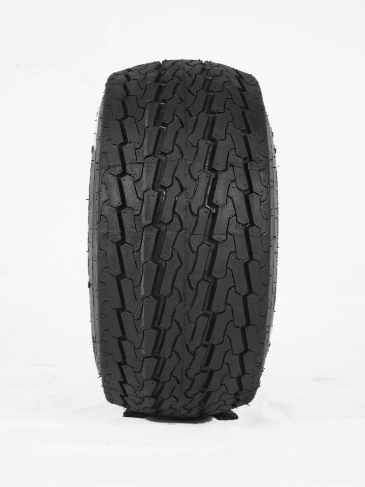An up-close, vertical shot shows the tread pattern of a black rubber tire against a plain white background. The tread features a symmetrical, interlocking "S" or zigzag lug design with deep grooves and siping, typical of an all-terrain or heavy-duty trailer tire. 20.5X8.00-10 10PR POWER PLUS TUBELESS - AG Machinery Depot